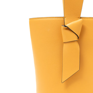 bolso tipo bucket de piel amarillo hecho a mano con detalle de nudo, asa superior y bandolera