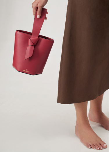 bolso tipo bucket de cuero cereza hecho a mano con detalle de nudo, asa superior y bandolera